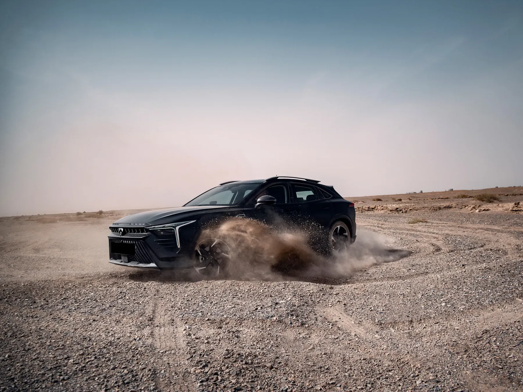 Black ABADAL NOVO drifting and kicking up dust in the desert